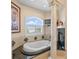 Luxurious bathroom with soaking tub, black granite countertop, fireplace, and a flat-screen TV at 11715 Taylor Rd, Thonotosassa, FL 33592