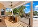 Outdoor kitchen with stainless steel grill, mini fridge and beautiful view of the backyard at 11715 Taylor Rd, Thonotosassa, FL 33592