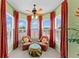 Cozy sitting area with large windows, plantation shutters, red drapes, and comfortable seating at 11715 Taylor Rd, Thonotosassa, FL 33592