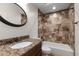 Bathroom featuring granite countertop vanity, decorative tile shower, and round mirror at 11910 Keating Dr, Tampa, FL 33626