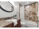 Bathroom features a granite vanity, oval mirror and tiled bathtub with a shower at 11910 Keating Dr, Tampa, FL 33626