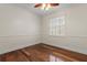 Bedroom featuring hardwood floors, a ceiling fan and a window with shutter blinds at 11910 Keating Dr, Tampa, FL 33626