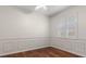Bedroom featuring paneled walls, hardwood floors, and bright natural light from the window at 11910 Keating Dr, Tampa, FL 33626