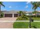 Charming single-story home with a well-manicured lawn, lush landscaping, and a three-car garage at 11910 Keating Dr, Tampa, FL 33626