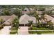 Beautifully landscaped home with a three-car garage, lush green lawn, and mature palm trees at 11910 Keating Dr, Tampa, FL 33626