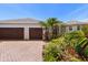 Beautiful single-story home showcasing lush landscaping and a brick driveway leading to a three-car garage at 11910 Keating Dr, Tampa, FL 33626