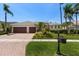 Well-maintained home with a manicured lawn, mature landscaping, and a brick-paved driveway at 11910 Keating Dr, Tampa, FL 33626