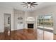 Bright living room with fireplace, ceiling fan, wood floors, and access to outdoor pool area at 11910 Keating Dr, Tampa, FL 33626