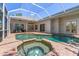Inviting backyard pool and spa with screened enclosure and outdoor entertaining space at 11910 Keating Dr, Tampa, FL 33626