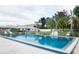 Community pool surrounded by lounge chairs, palm trees, and well-maintained landscaping at 12400 Park Blvd # 522, Seminole, FL 33772