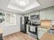 Efficient kitchen featuring modern appliances, a bright window, and ample counter space at 129 Cypress Ct, Oldsmar, FL 34677
