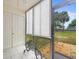 Enclosed lanai with white tile floors offers extra space with views of the lush landscape at 129 Cypress Ct, Oldsmar, FL 34677