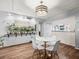 Living room featuring wood-look floors, stylish light fixture, and a wall of healthy plants at 129 Cypress Ct, Oldsmar, FL 34677