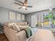 Comfortable living room featuring a plush sofa, fan, and natural light, perfect for relaxation and entertaining at 129 Cypress Ct, Oldsmar, FL 34677