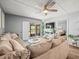 Comfortable living room featuring a plush sofa, fan, and natural light, perfect for relaxation and entertaining at 129 Cypress Ct, Oldsmar, FL 34677