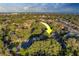 Expansive aerial view of a residential neighborhood with lush greenery and a glimpse of the ocean skyline in the distance at 14073 Jennifer Ter, Largo, FL 33774