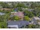 Aerial view of a home featuring a screened pool, complemented by the serene, tree-lined streets of a suburban neighborhood at 14073 Jennifer Ter, Largo, FL 33774