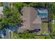 Aerial view of home with a screened-in pool and spacious green backyard at 14073 Jennifer Ter, Largo, FL 33774