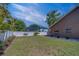 Backyard featuring a pristine lawn, complemented by a white fence for added privacy and aesthetic appeal at 14073 Jennifer Ter, Largo, FL 33774