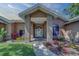 Inviting home entrance featuring a brick-accented portico and meticulously landscaped front yard at 14073 Jennifer Ter, Largo, FL 33774