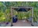 Gazebo with a grill and seating, surrounded by lush tropical foliage, perfect for outdoor relaxation at 14073 Jennifer Ter, Largo, FL 33774