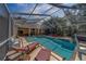 Screened pool area with beautiful in-ground pool, hot tub, sun loungers, and outdoor seating at 14073 Jennifer Ter, Largo, FL 33774
