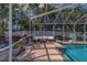 The enclosed pool features seating, a rug, and a basketball hoop for fun in the sun at 14073 Jennifer Ter, Largo, FL 33774