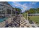 Screened-in pool area with checkered tile, views of lush greenery, and ample lounge space at 14073 Jennifer Ter, Largo, FL 33774