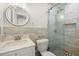 Updated bathroom featuring decorative tile, glass shower, and a vanity with a white countertop at 14917 Philmore Rd, Tampa, FL 33613