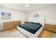 Bright bedroom with two windows, wood dresser, and modern platform bed with stylish green blanket at 14917 Philmore Rd, Tampa, FL 33613