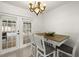Bright dining area features a stylish table and chairs, a chandelier, and sliding doors leading to the backyard at 14917 Philmore Rd, Tampa, FL 33613
