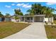 Attractive single-story home with a carport, landscaped front yard, and freshly painted exterior at 14917 Philmore Rd, Tampa, FL 33613