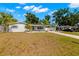 Charming single-story home with a well-manicured lawn, mature trees, and a carport at 14917 Philmore Rd, Tampa, FL 33613