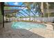 Backyard screened-in pool with sunny skies and stone-tiled patio for relaxing and entertaining at 14917 Philmore Rd, Tampa, FL 33613