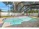 Sparkling in-ground pool is surrounded by a screened enclosure and a patio area, perfect for outdoor enjoyment at 14917 Philmore Rd, Tampa, FL 33613