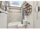 Bathroom features a bathtub with shower, skylight and a wooden shelving unit with decor at 1502 Creekbend Dr, Brandon, FL 33510