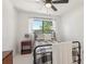 Bright bedroom features a black iron frame bed, ceiling fan, and natural light at 1502 Creekbend Dr, Brandon, FL 33510