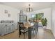 Dining room with a rustic wooden table, blue chairs and cabinetry, and a large window viewing greenery at 1502 Creekbend Dr, Brandon, FL 33510
