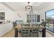 A dining room featuring a rustic wooden table, blue chairs and cabinetry with a modern light fixture at 1502 Creekbend Dr, Brandon, FL 33510