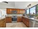 Kitchen with wood cabinets, granite countertops, stainless steel appliances, and a large window at 1502 Creekbend Dr, Brandon, FL 33510