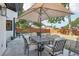 Inviting patio with a dining set shaded by a large umbrella and a well-maintained brick-paved area for outdoor gatherings at 1502 Creekbend Dr, Brandon, FL 33510