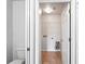 Bright laundry room featuring tile floors, washer/dryer hookups, and storage shelf at 1506 Lenton Rose Ct, Trinity, FL 34655
