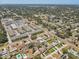 Expansive aerial view of a residential neighborhood with tree-lined streets, community pool and a nearby shopping center at 1510 Blue Sea St, Clearwater, FL 33756
