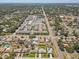 Expansive aerial view of a residential neighborhood with tree-lined streets, community pool and a nearby shopping center at 1510 Blue Sea St, Clearwater, FL 33756