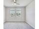 Bright bedroom with two windows offering natural light, neutral walls, and a ceiling fan at 1510 Blue Sea St, Clearwater, FL 33756