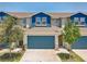 Charming townhouse featuring a blue facade, a two-car garage, and lovely landscaping at 1510 Blue Sea St, Clearwater, FL 33756
