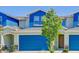 Beautiful townhouse featuring a blue facade, a two-car garage, and lovely landscaping at 1510 Blue Sea St, Clearwater, FL 33756