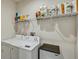 Functional laundry room with a washer, dryer, and shelf space for storage at 1510 Blue Sea St, Clearwater, FL 33756