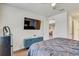 Comfortable bedroom with a TV, storage cabinet, and view into the hallway from the open doorway at 1510 Blue Sea St, Clearwater, FL 33756