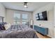 Well-lit bedroom featuring wood floors, windows, a TV, and modern furniture for comfortable living at 1510 Blue Sea St, Clearwater, FL 33756